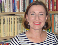 Marielle Rebbechi, Founder of Cereal Readers Smiling head and shoulders of Marielle Rebbechi in front of book shelves